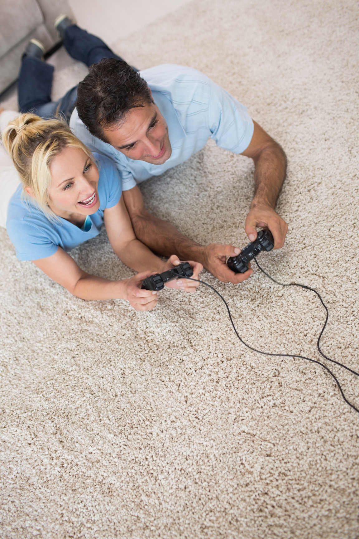 Couple playing video games on area rug